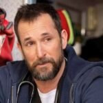 Dr Robby cries sitting in the back of an ambulance