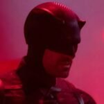 man in daredevil costume against a dimly lit purplish pink background