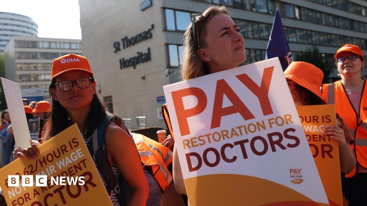 Resident doctors on strike hold placards outside St. Thomas's hospital in London
